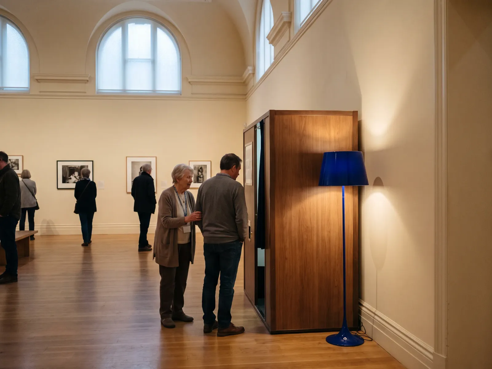 A quiet branded photo station in a gallery space with a volunteer nearby